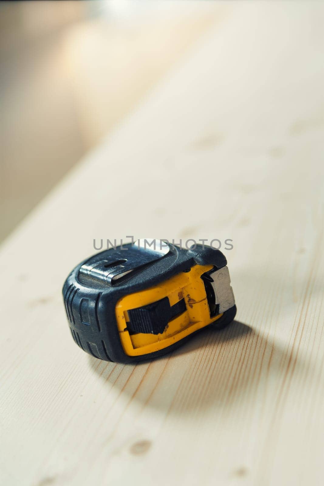 A carpenter's tape measure resting on a rough wooden surface, like a board, ready to become something else. Precision is the opposite of approximation.