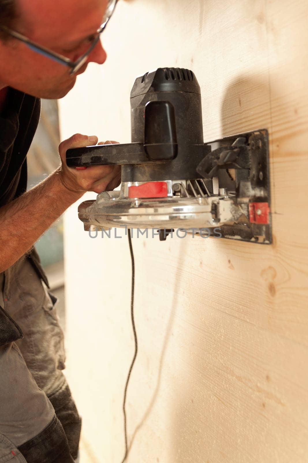 Man in action at work with powerful tools. Carpenter is sanding a wooden surface. The old planers are no longer being used.