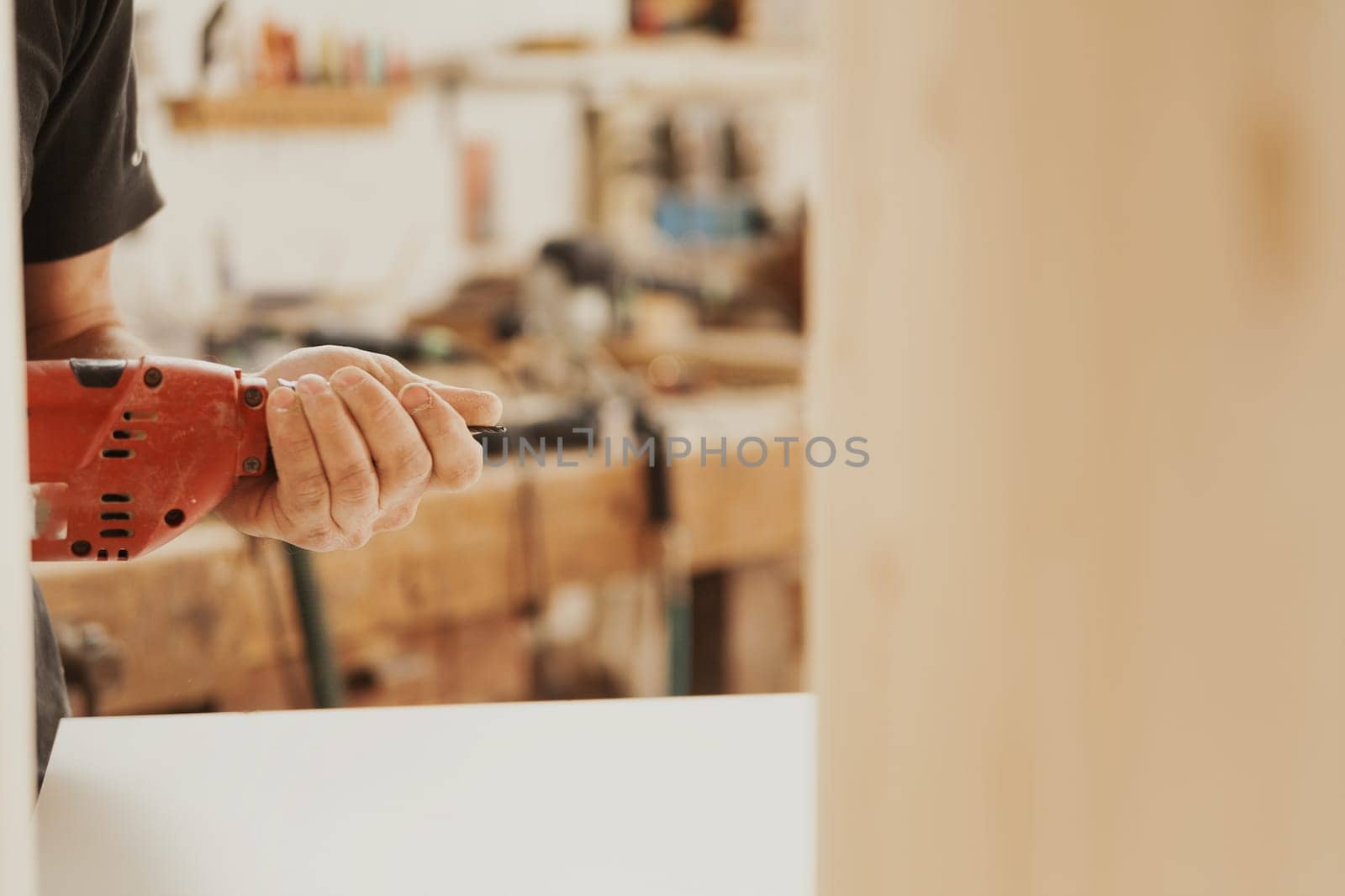 Detail in focus: a beautiful red drill is a faithful tool and companion of the woodworker. In his craft store he finds it reliable and uses it skillfully.