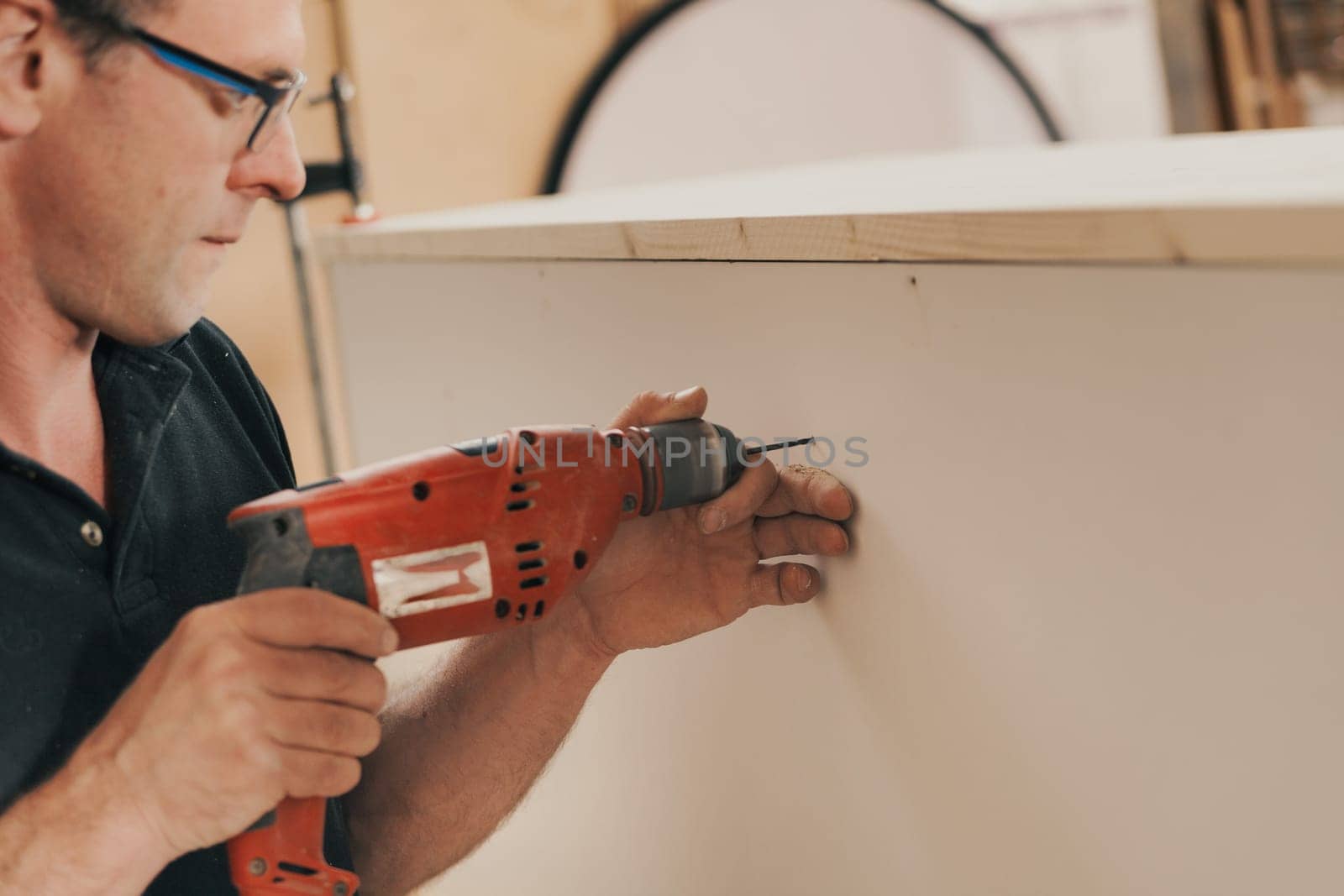 Detail in focus: a beautiful red drill is a faithful tool and companion of the woodworker. In his craft store he finds it reliable and uses it skillfully.