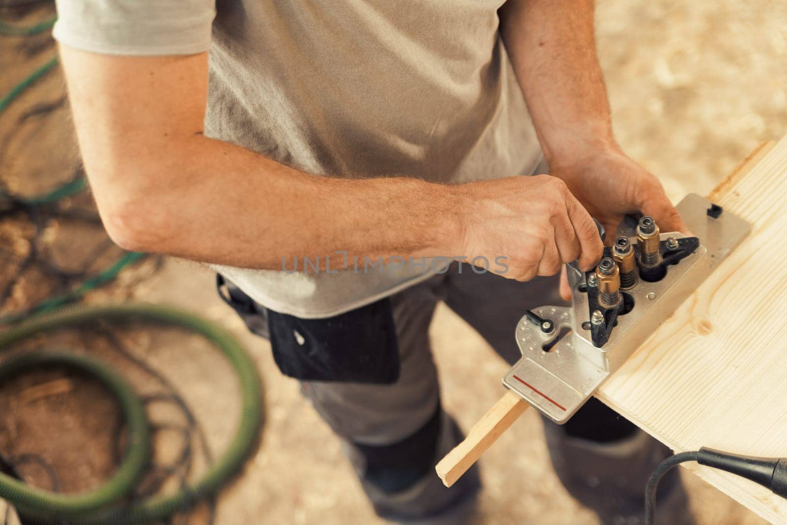 Detail in focus of a drilling jig used by the woodworker in his craft workshop. Although they can be self-made the multi-pattern carpenter's drilling jigs are convenient and professional.