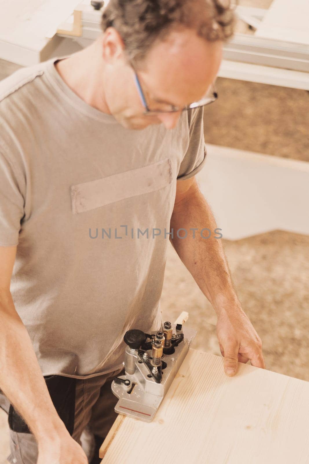 Detail in focus of a drilling jig used by the woodworker in his craft workshop. Although they can be self-made the multi-pattern carpenter's drilling jigs are convenient and professional.