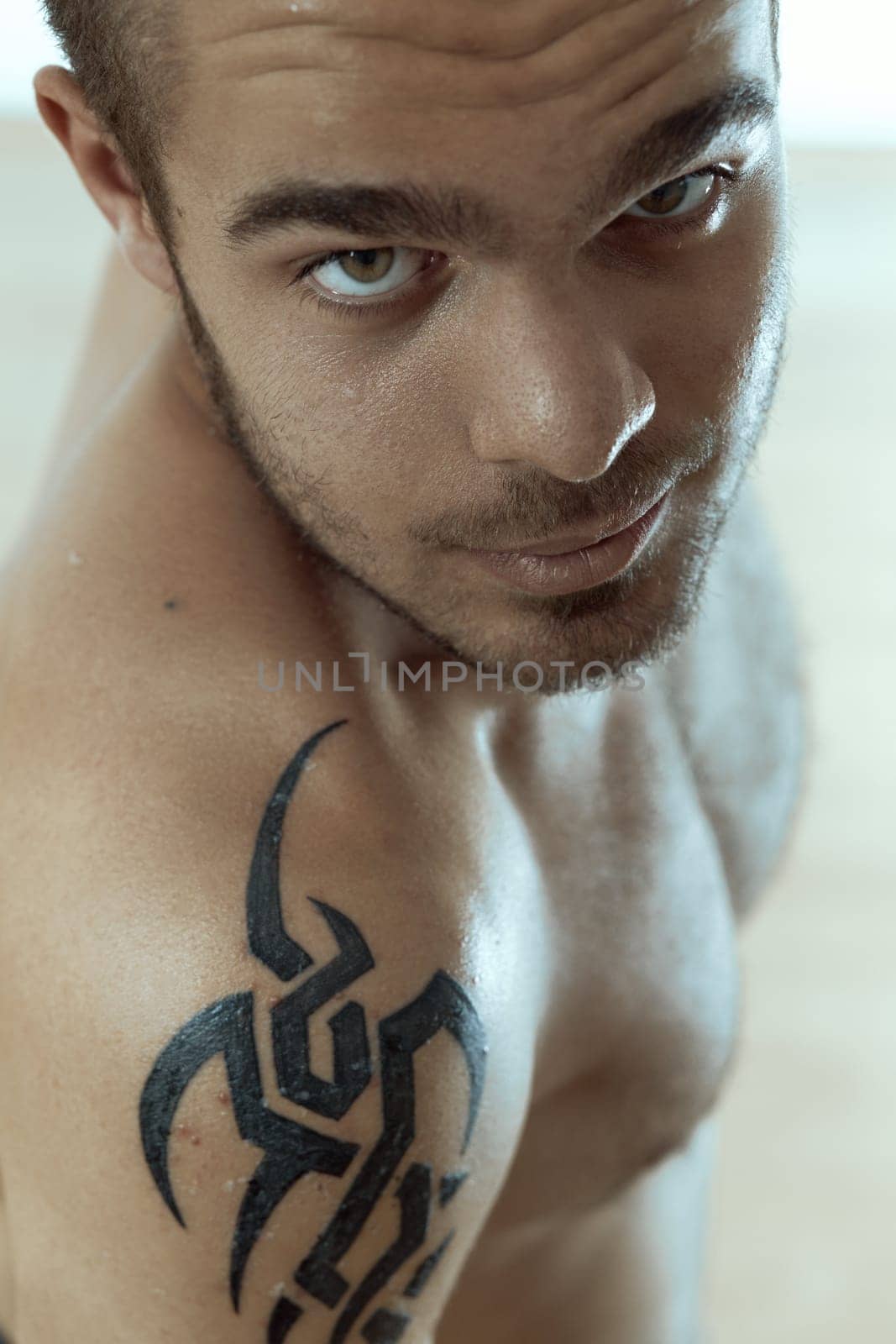 Focused young individual with intricate shoulder tattoo