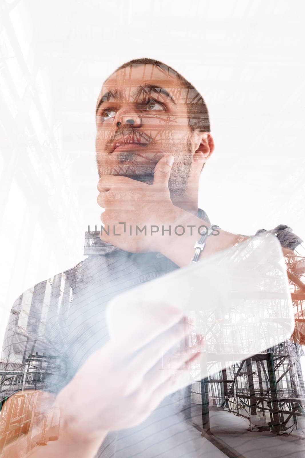 Double exposure of a man and a construction site portrays a blend of humanity and industry