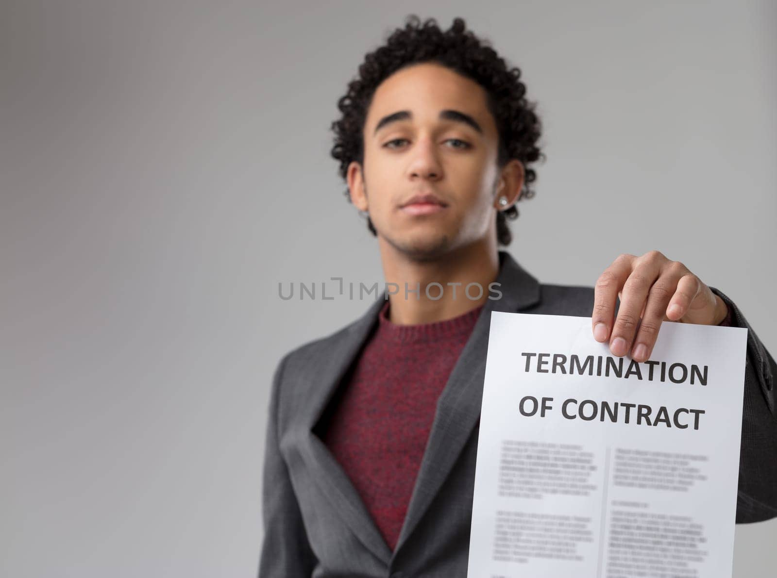Poised and with determination, he showcases a 'TERMINATION OF CONTRACT' notice to emphasize its gravity