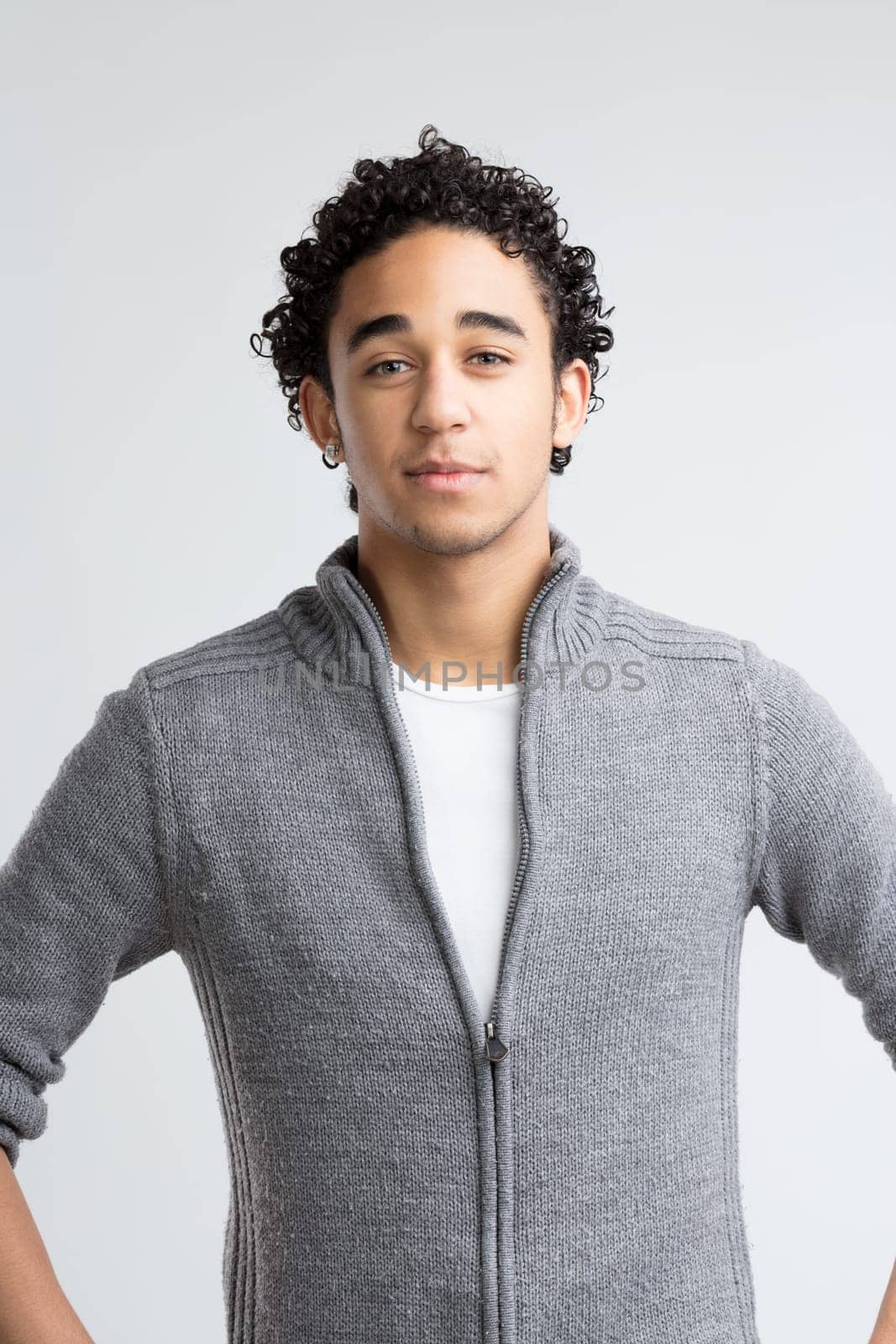 Green eyes, full of warmth, meet the viewer's gaze, with thick curly hair adding to his approachable appearance