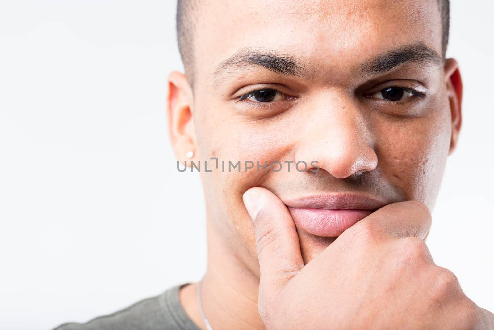 Extreme close-up portrait of black man, who's deep in thought. He's either on the cusp of a brilliant, money-making idea or suspicious of being deceived