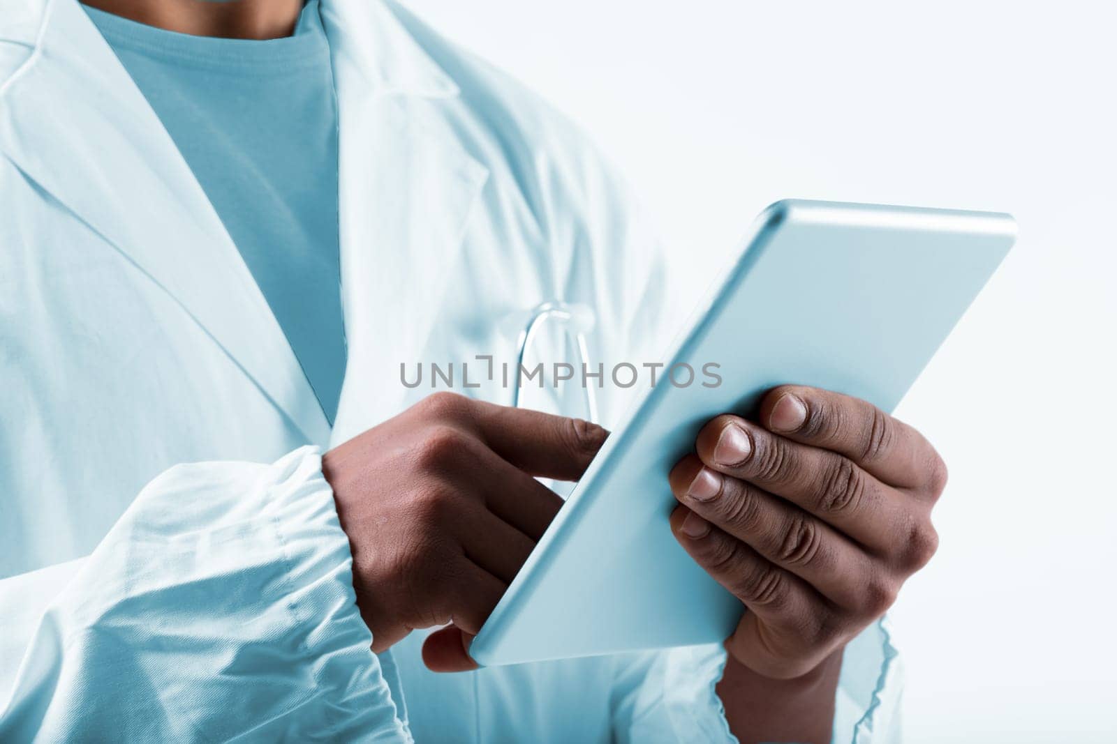 Black man, a laboratory expert in white coat, uses tablet for analyzing data, collaborating with organizations through internet. He's a proficient researcher or lab technician