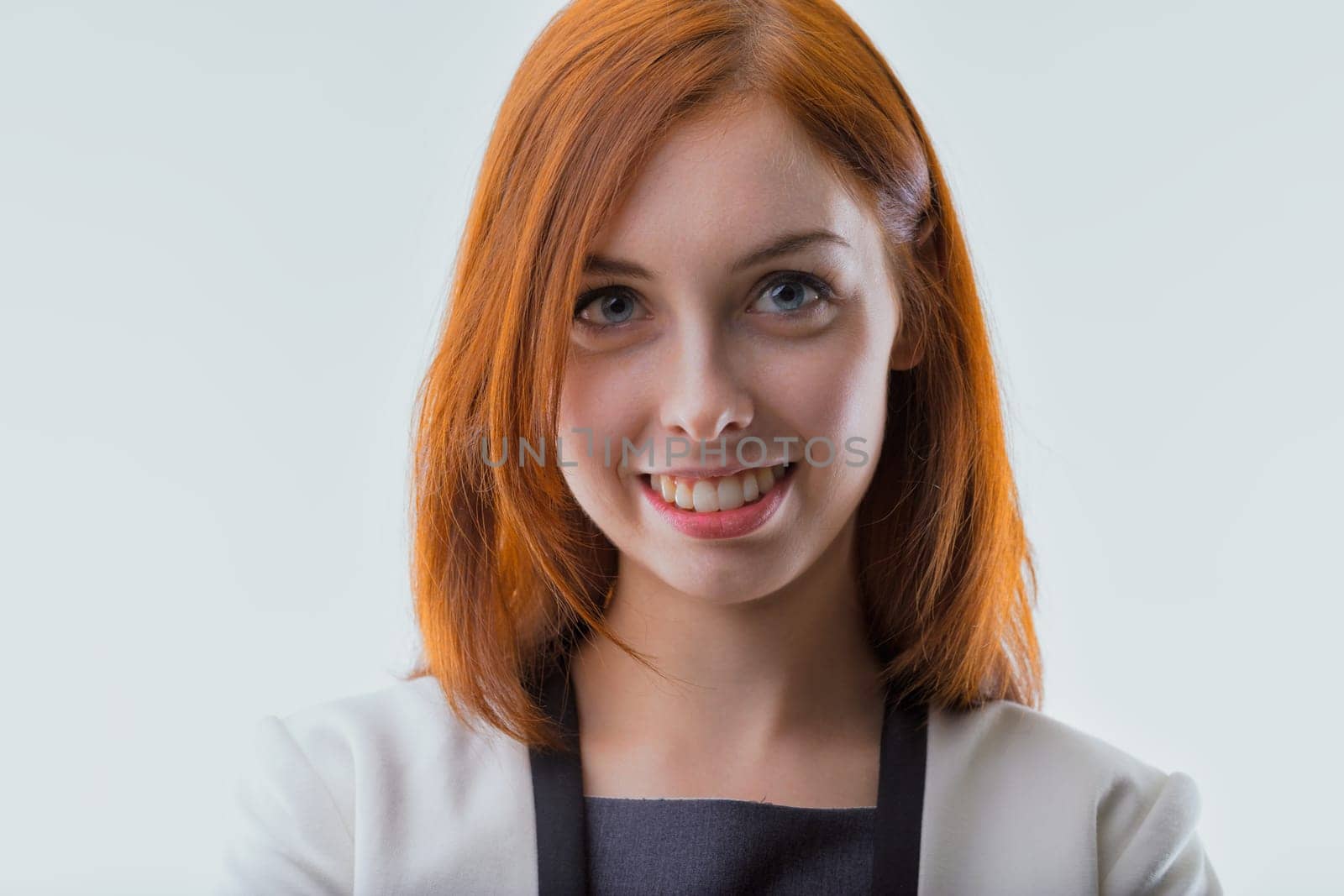woman's auburn hair and sincere smile convey a warm professionalism against a soft background
