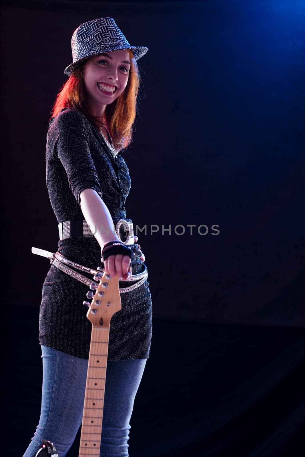 The electric guitarist, adorned in a sparkling garment, radiates happiness with each note played