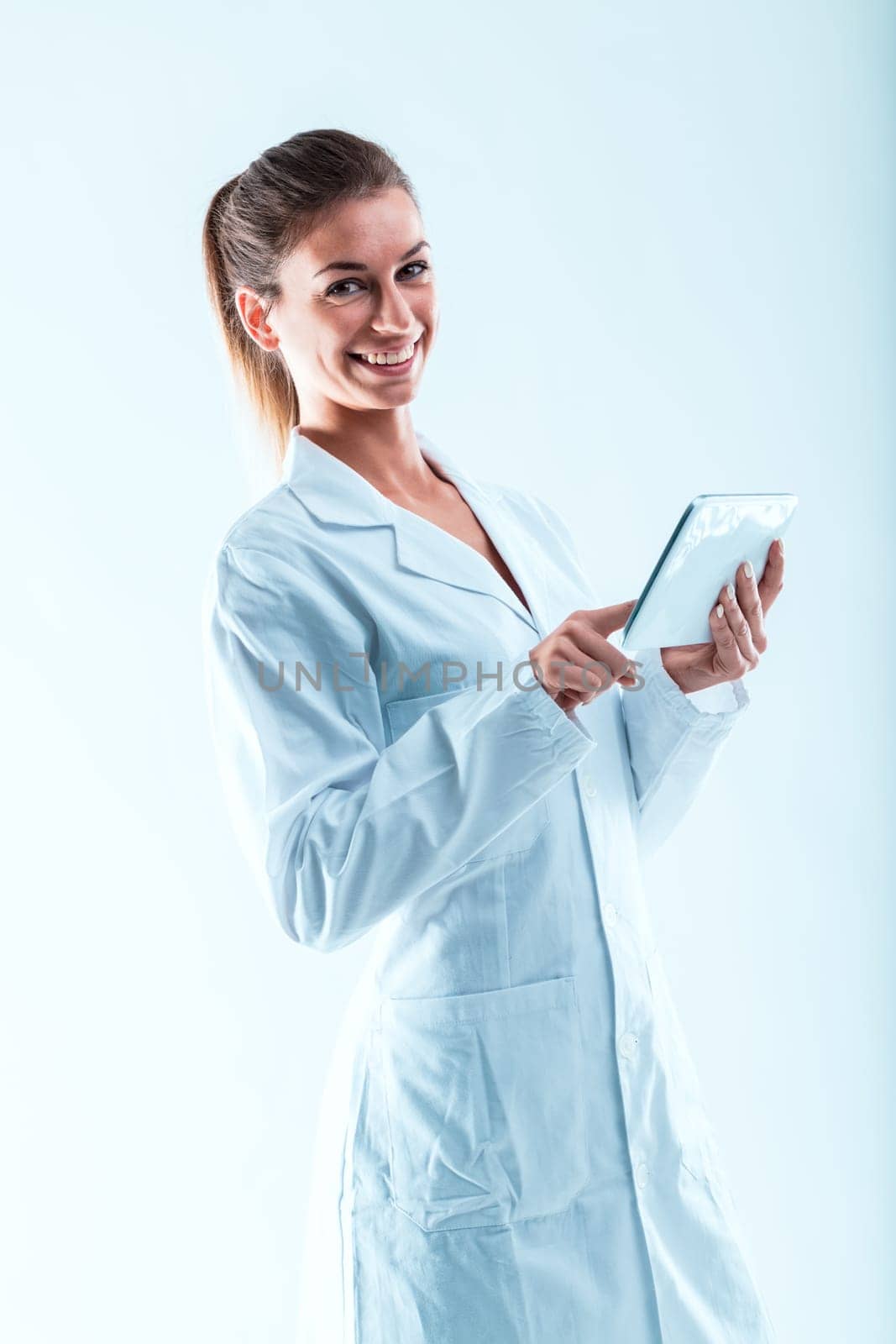 Smiling woman in white coat, holding a tablet, depicts an expert in STEM fields. Skilled in data treatment, she advocates using technology to confirm information and promote collaboration