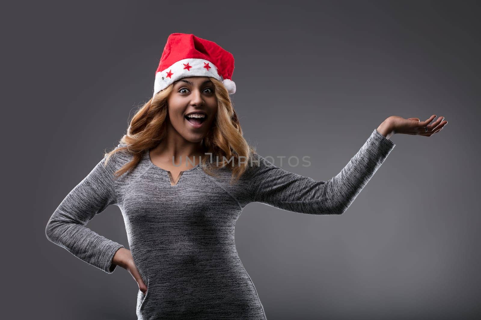 With a Santa hat and a gleeful smile, she embodies the cheer of the season as shows YOUR PRODUCT