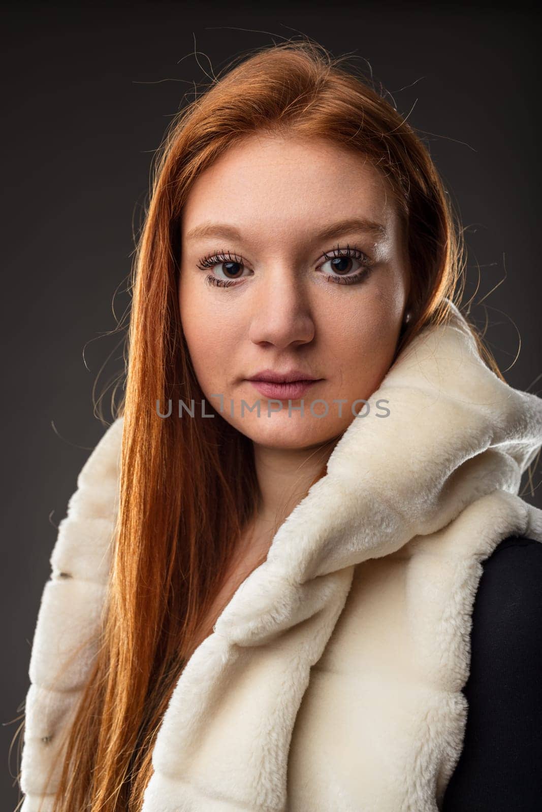 Red-haired woman stands out in a faux fur coat, her gaze intense