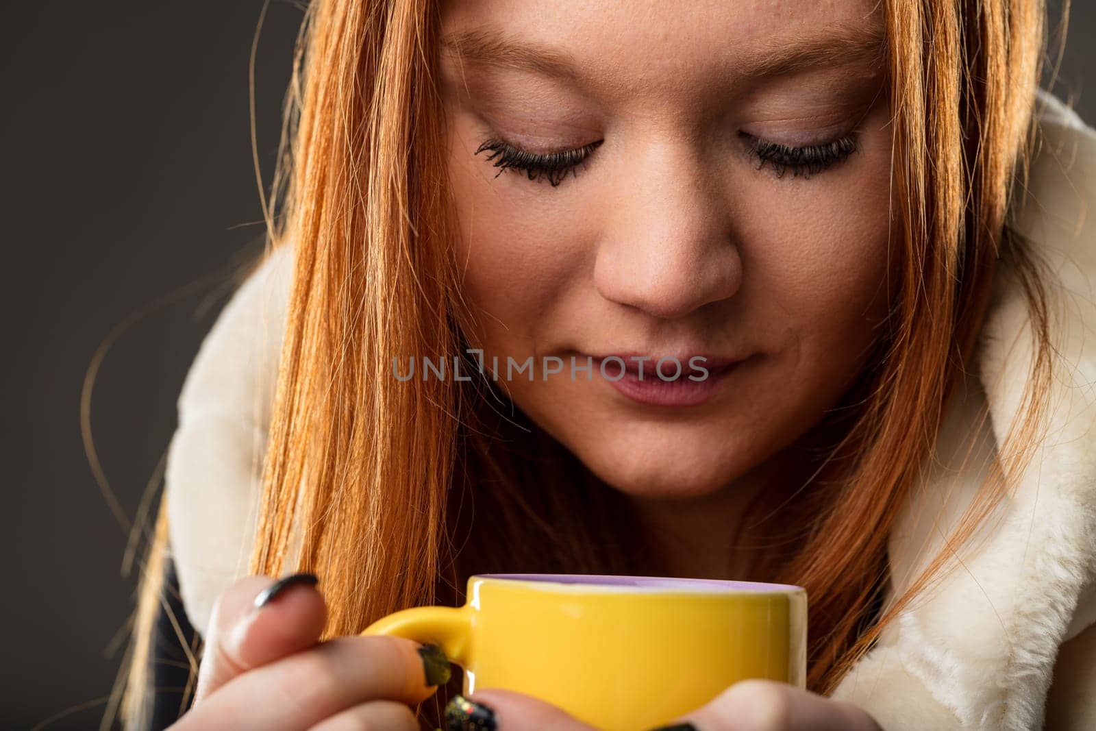 The warmth of the mug is mirrored in the woman's gaze, suggesting reflection and comfort