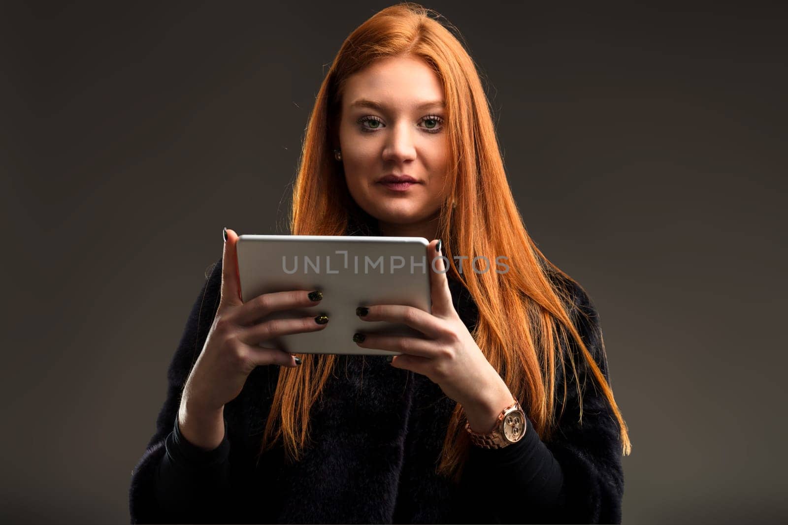 Tech-savvy woman with auburn hair effortlessly navigates through the latest apps on her device