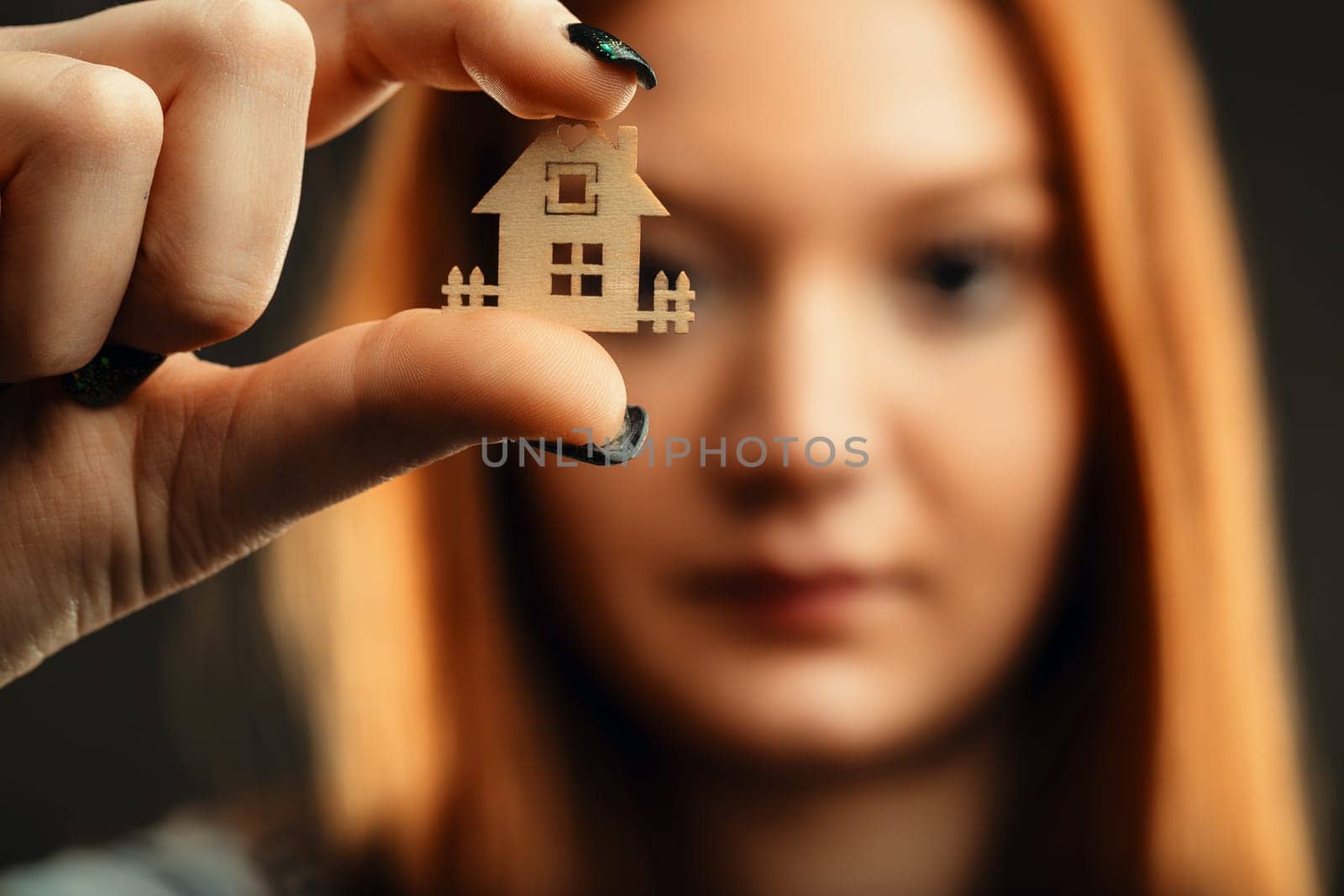 Young lady with striking hair color holding a representation of domesticity