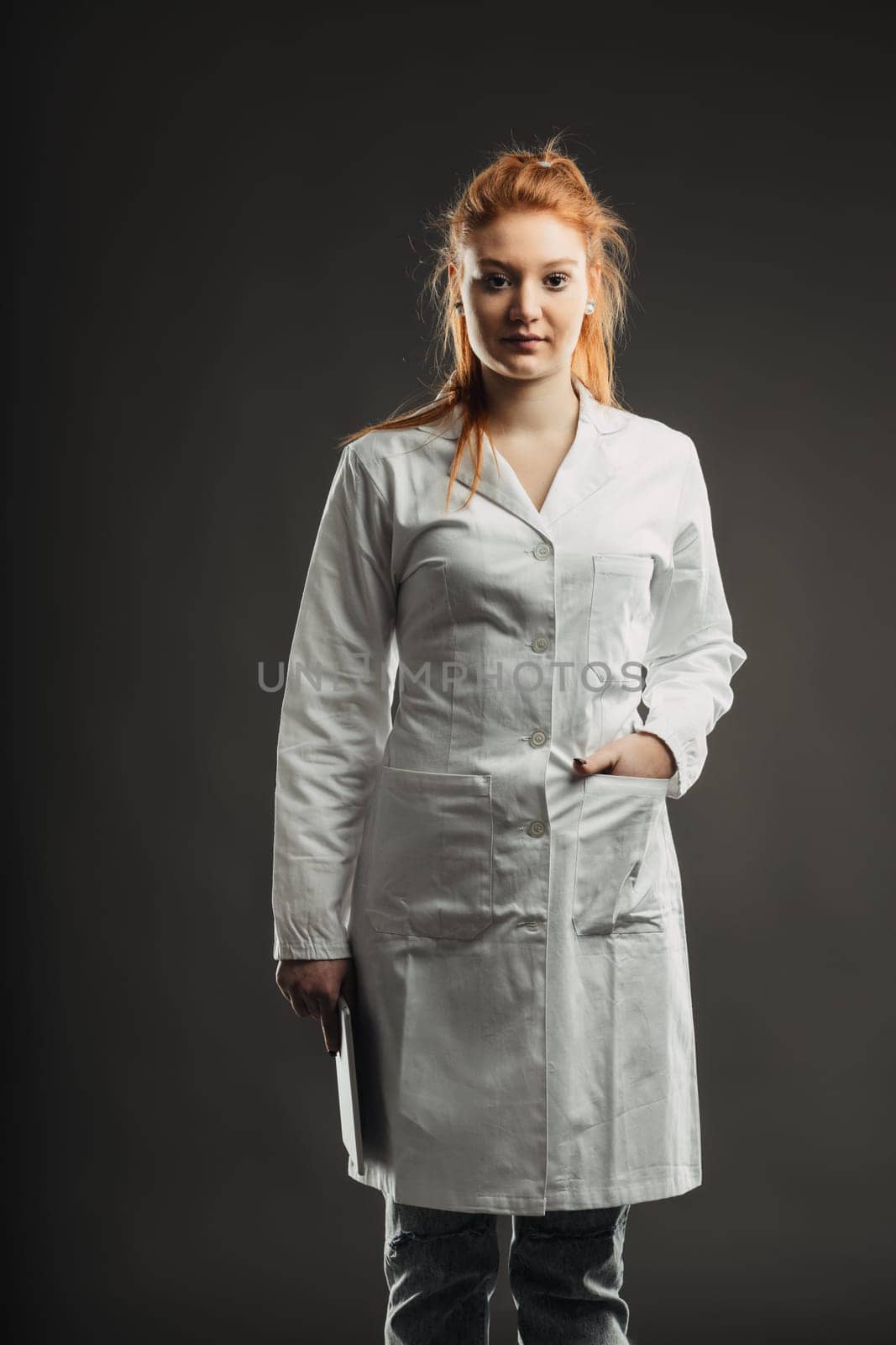Healthcare professional stands ready, laptop in hand, embodying the integration of technology in patient care