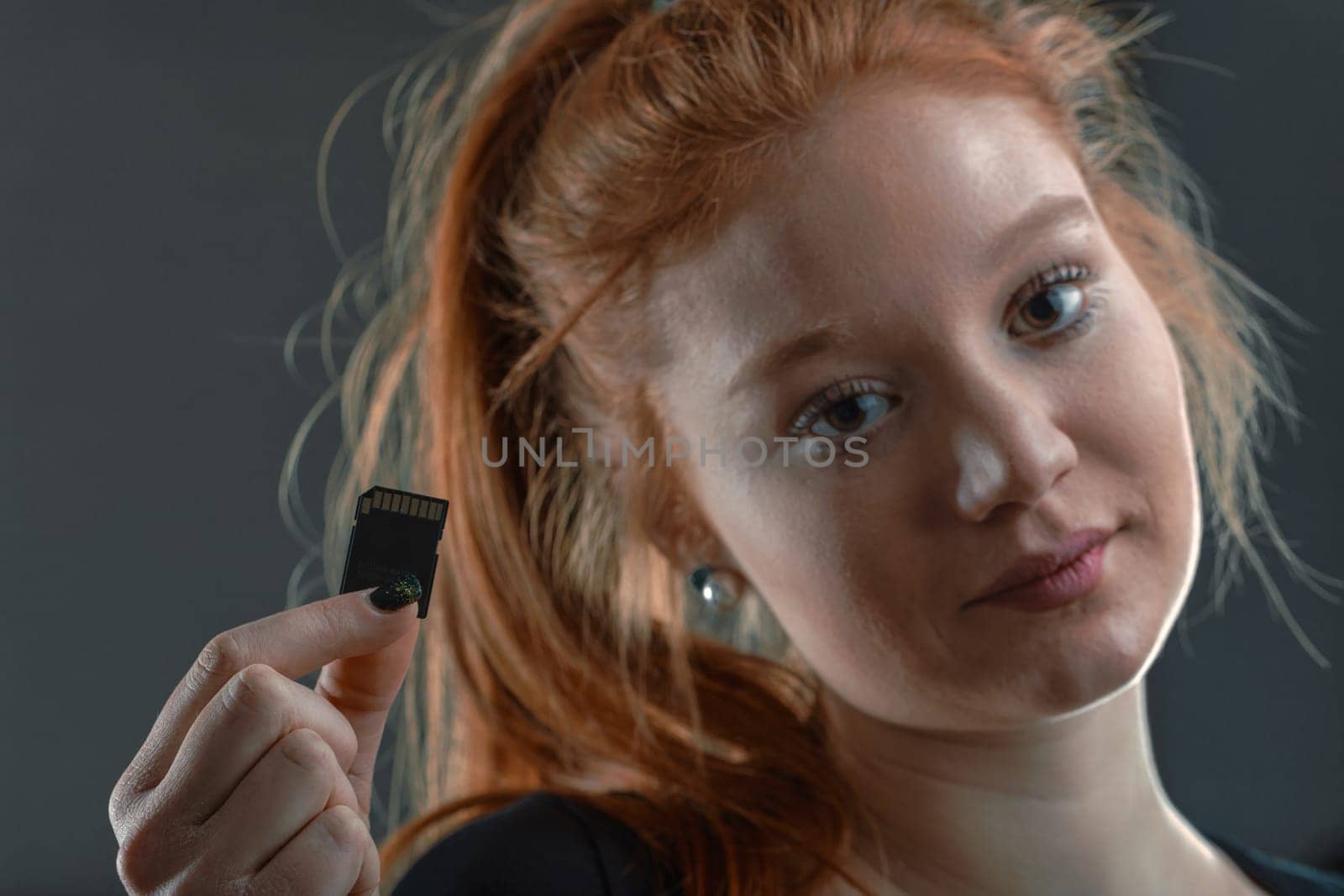 Young tech professional showcases an SD card, a staple in data storage and digital innovation
