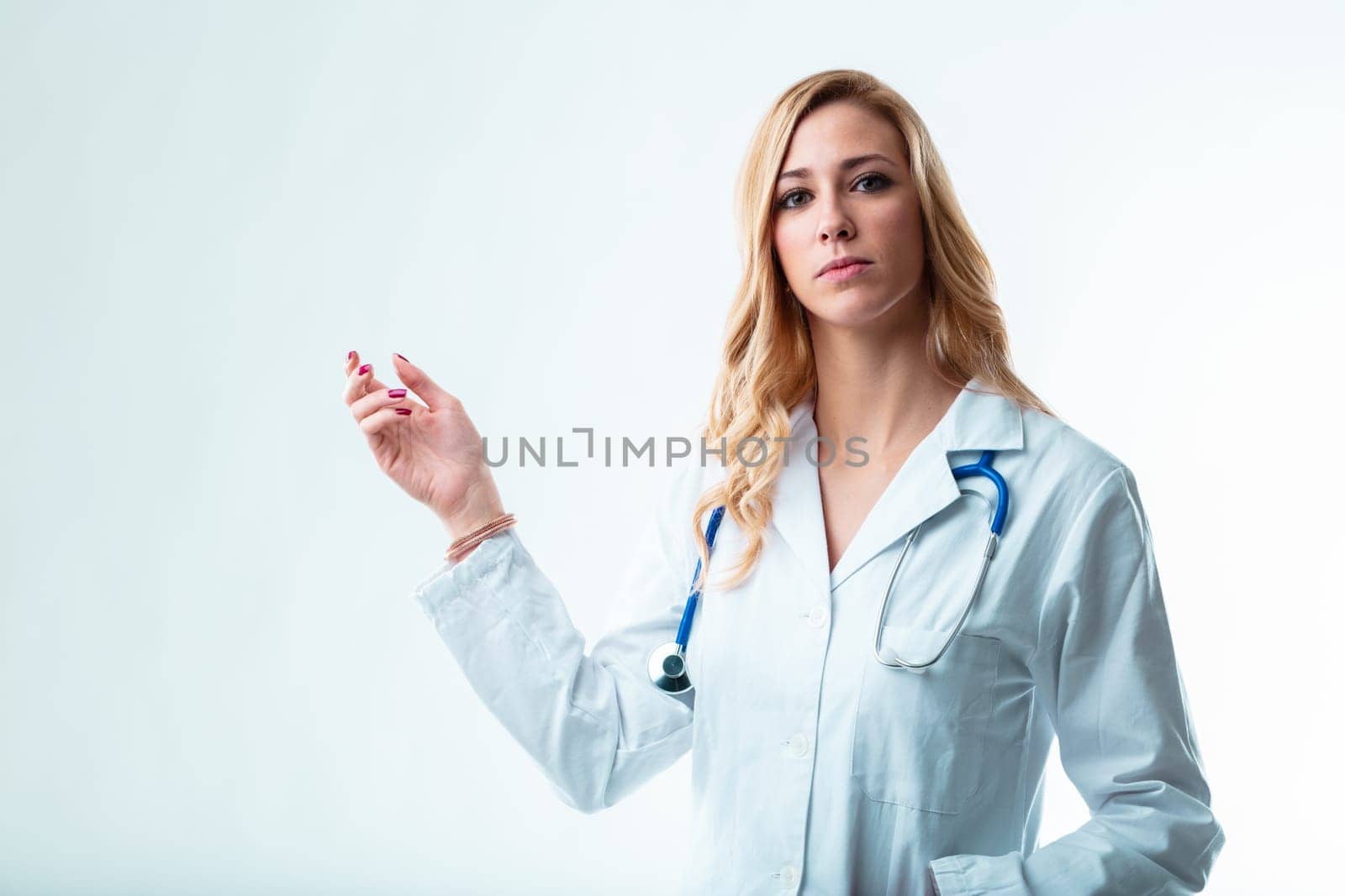 Female doctor in white coat, indicating copyspace for your product. She might be a family doctor, dentist or specialist