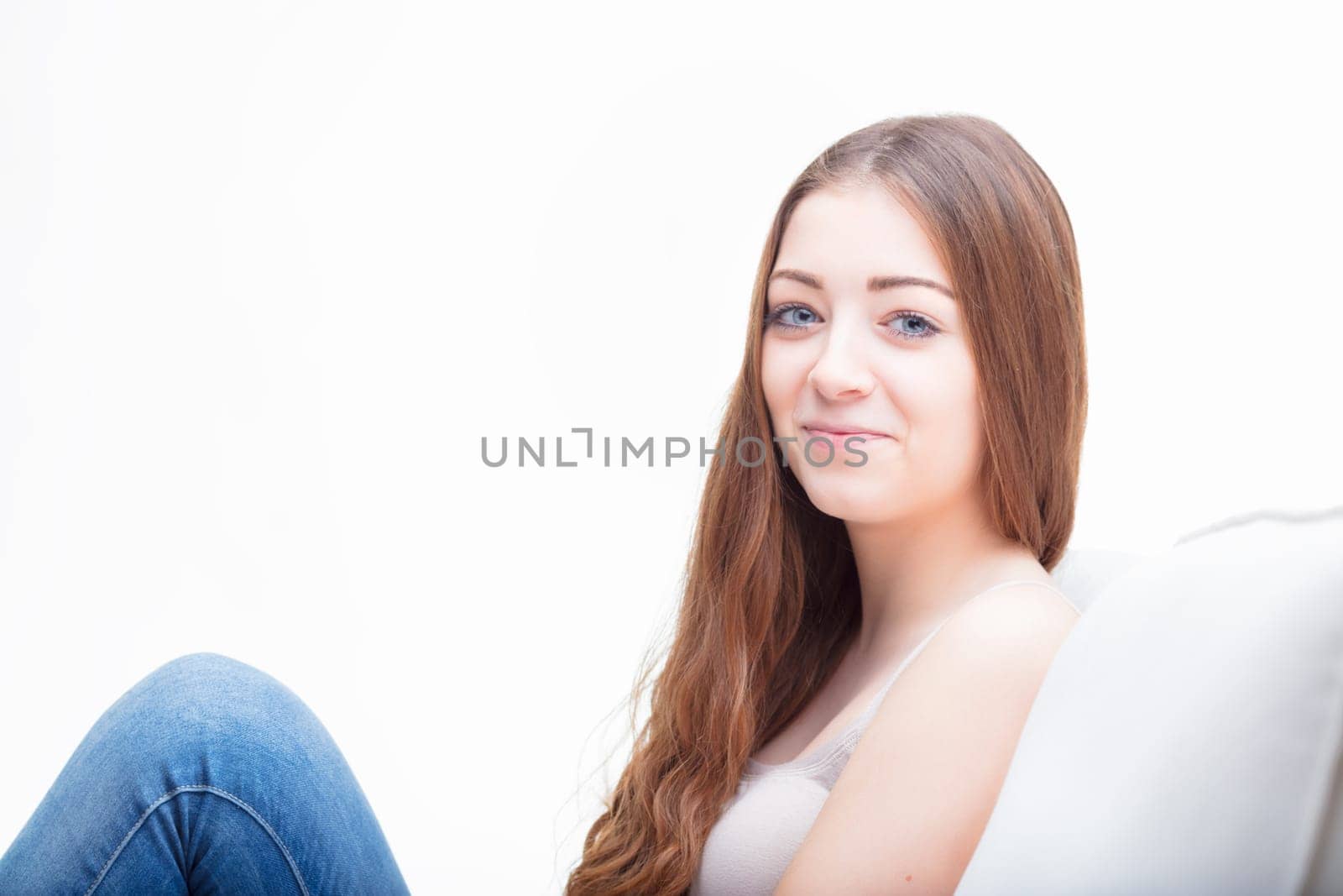 Relaxed at home, the woman's contented expression speaks to a moment of serene repose on a cozy sofa