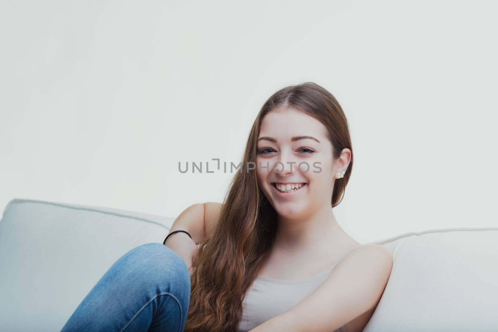 Comfortable in her own space, the young lady's casual pose and soft gaze suggest a peaceful ease