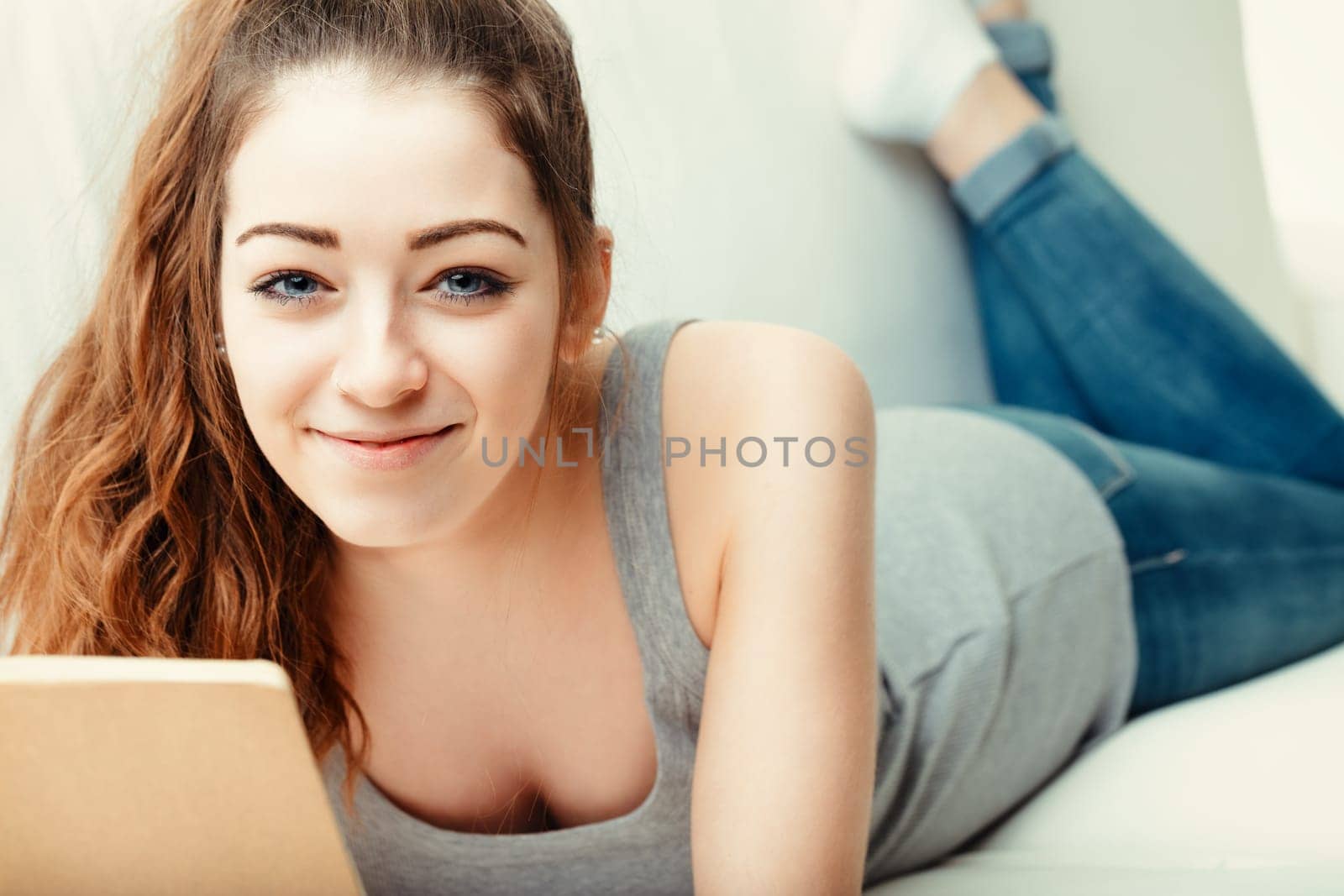 She seems to capture fleeting thoughts in her notebook, the comfort of the couch complementing her creative leisure
