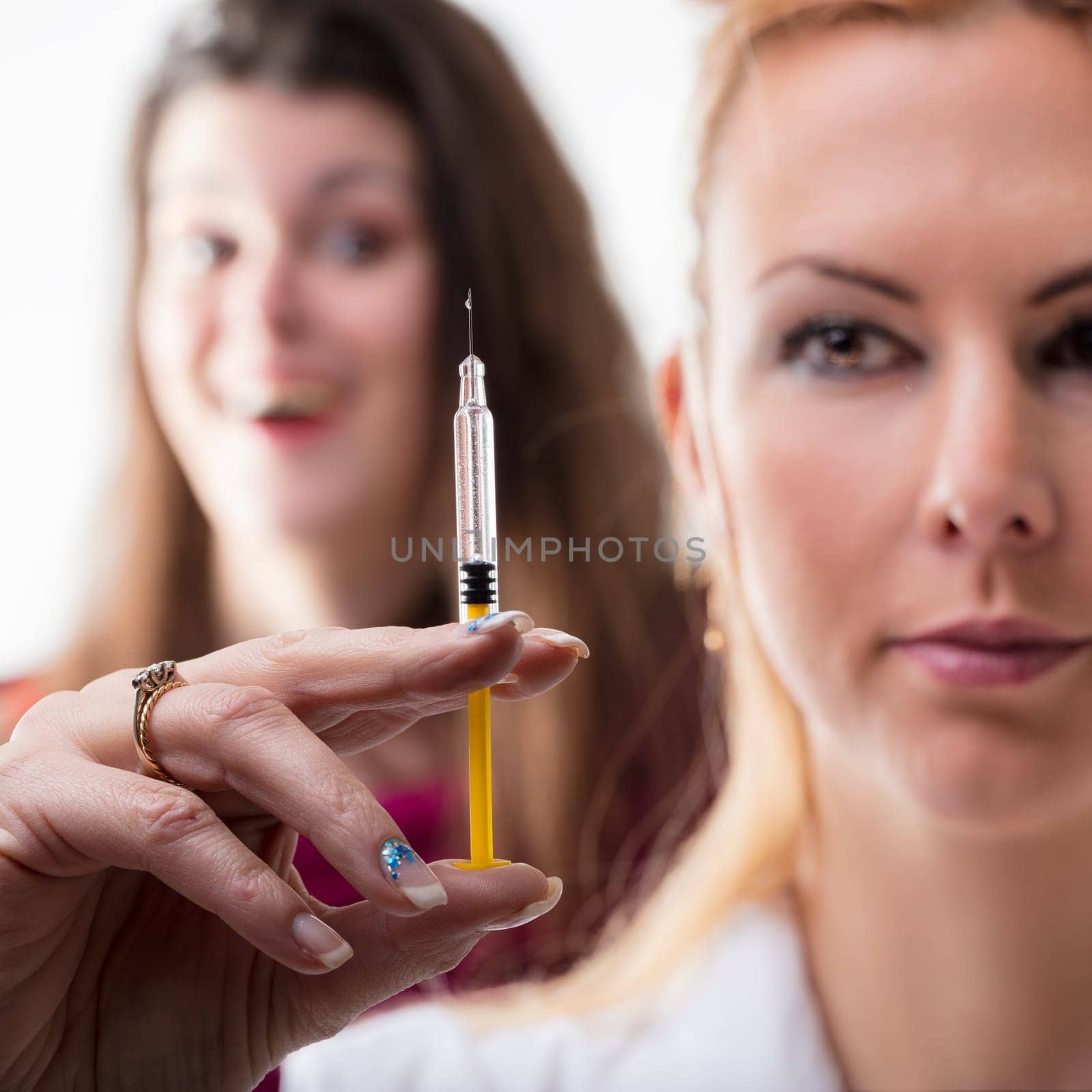 Syringe examination by a healthcare worker, observed by an apprehensive individual