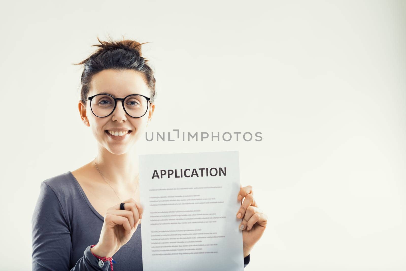 optimistic woman proudly presents an application form, symbolizing a step towards new beginnings