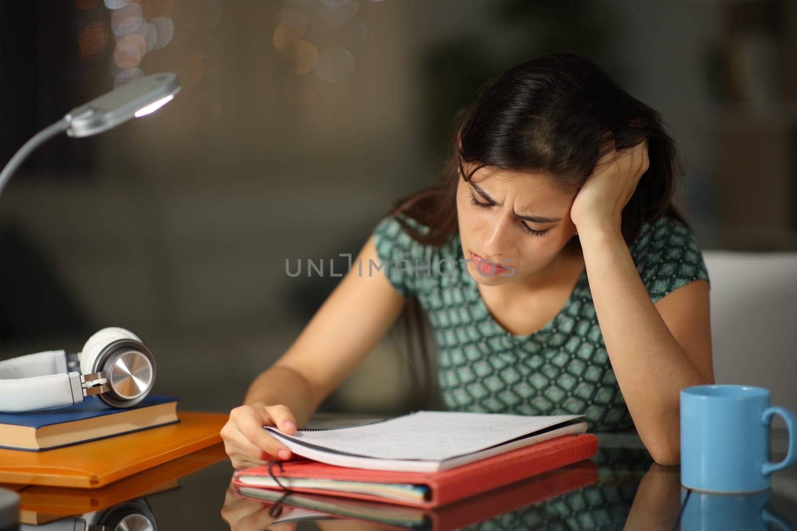 Frustrated student in the night trying to memorize notes at home