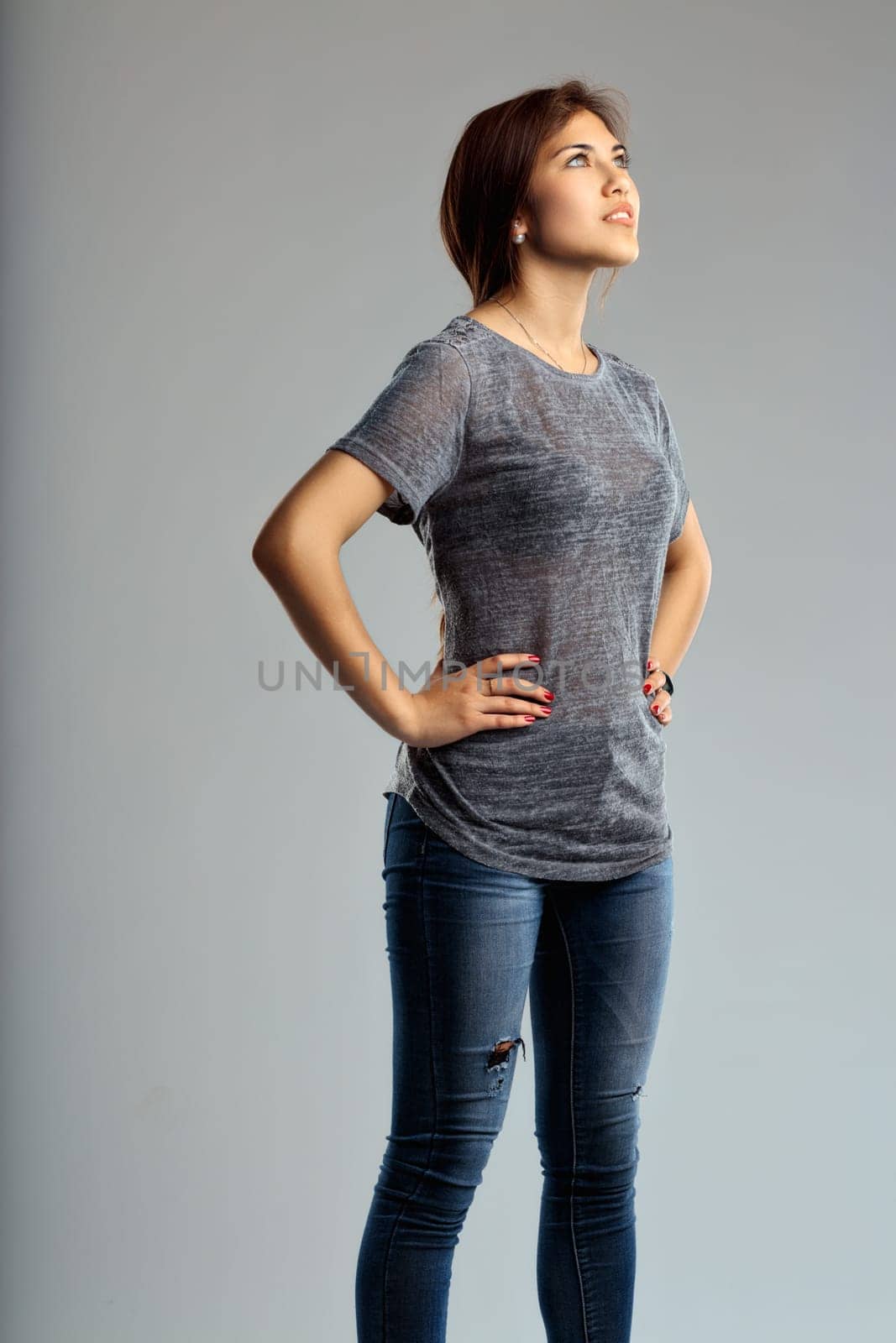 Poised and reflective, the womans upward gaze matches her laid-back yet fashionable outfit