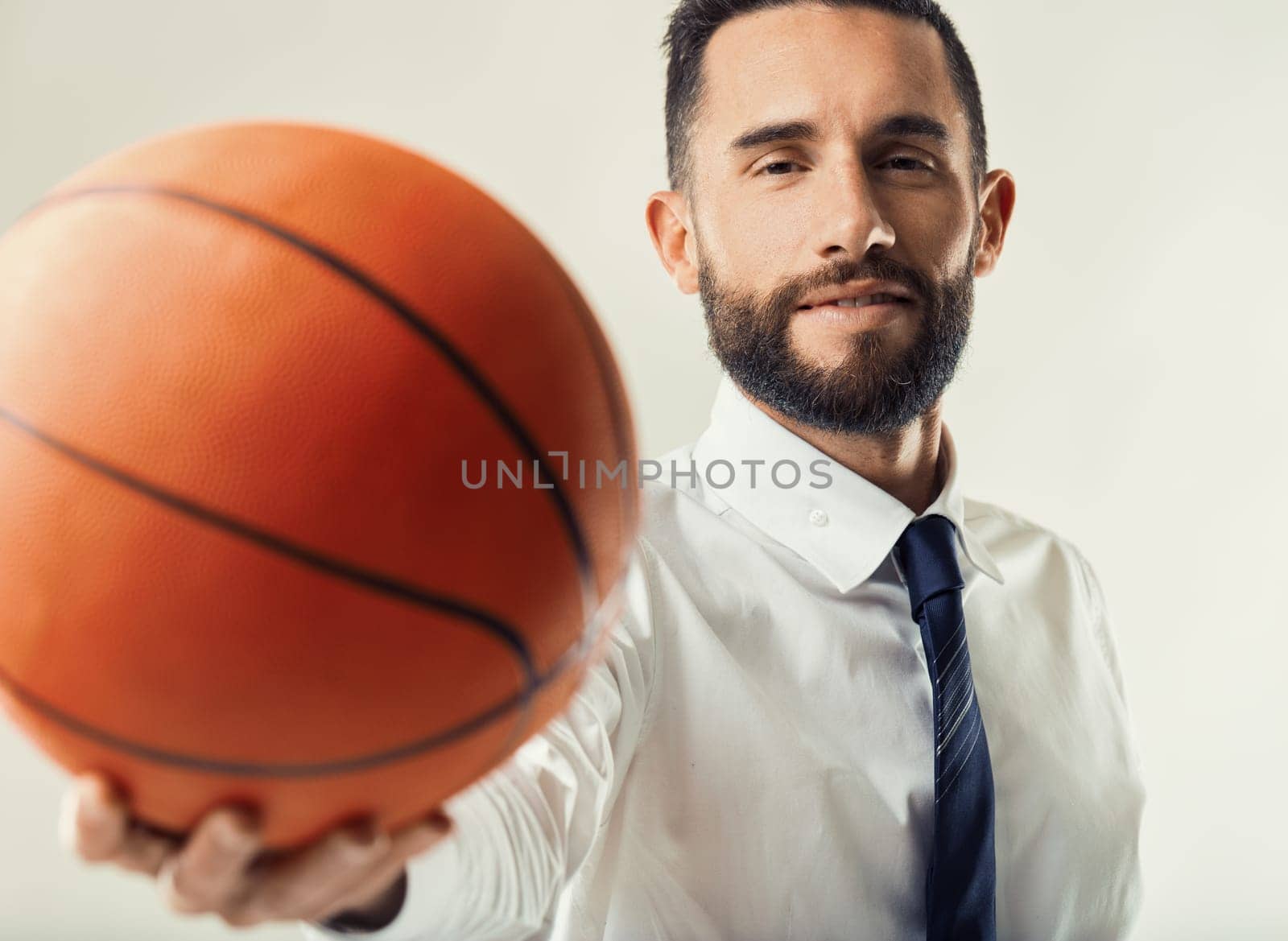 Determined executive with a basketball symbolizes teamwork and goal-setting in a business context