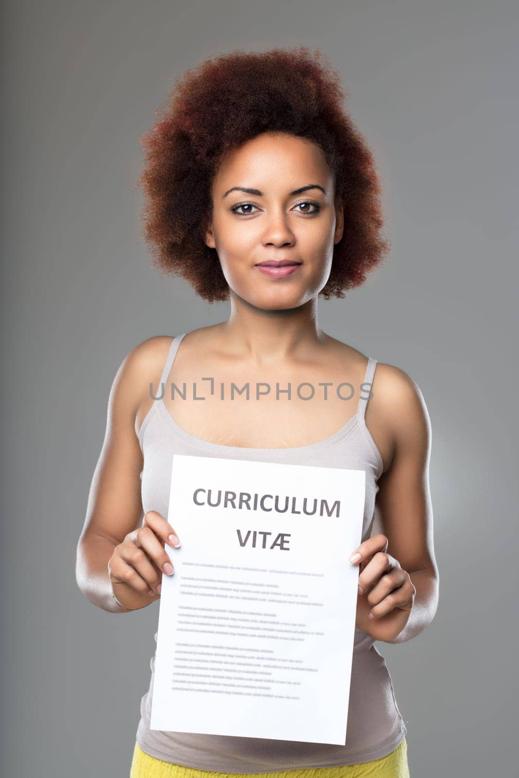 Woman holding her resume with a hopeful expression, anticipating career advancement