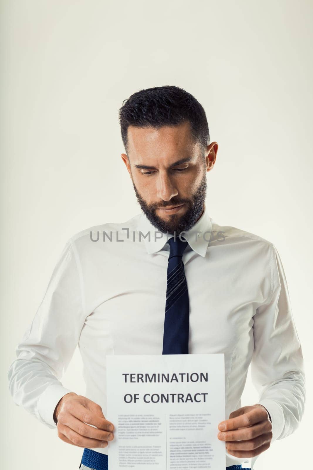 Disappointed businessman examines the terms of a contract termination, considering his next steps
