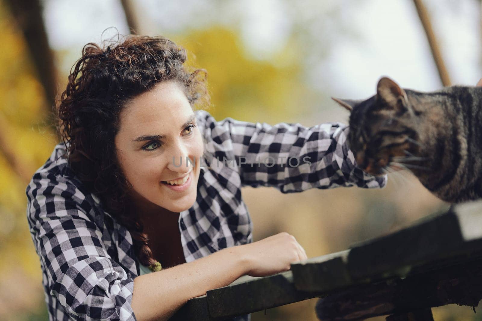 Portrait of feline with human. Portrait of woman with cat. In the woods a woman and a cat meet and caresses are bestowed. Who enjoys it more? Let's find out.