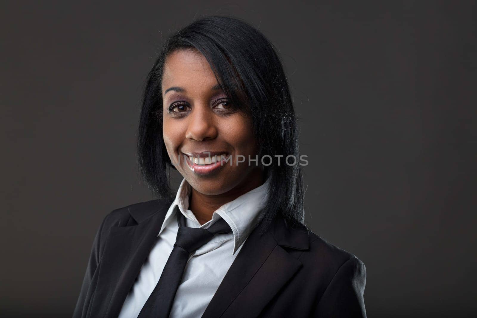Professional and poised, this woman's warm smile and smart attire suggest a background in corporate settings