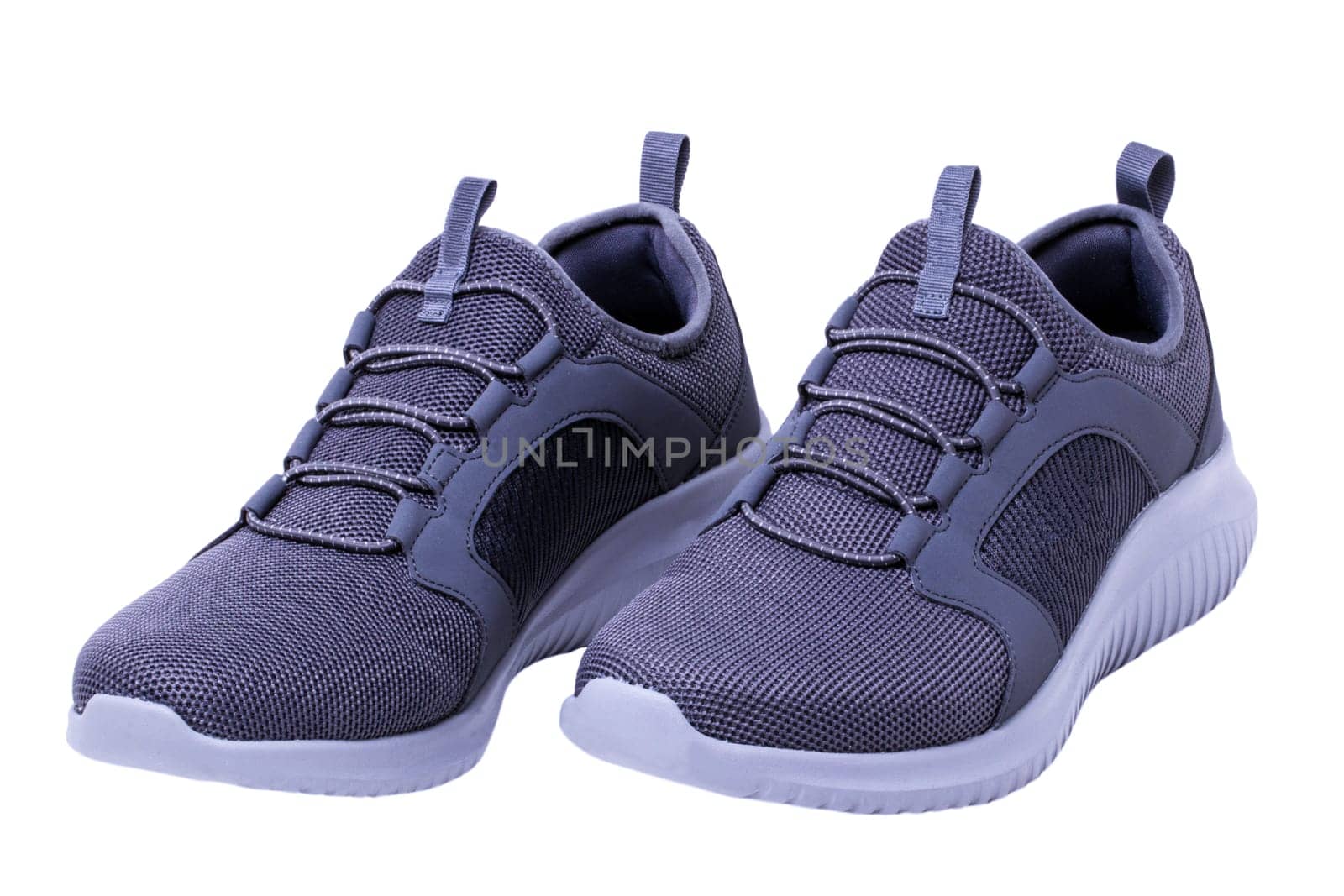Closeup of a pair of modern silver gray sneakers or sports shoes isolated on a white background. Elegant and trendy mans shoes. Macro.
