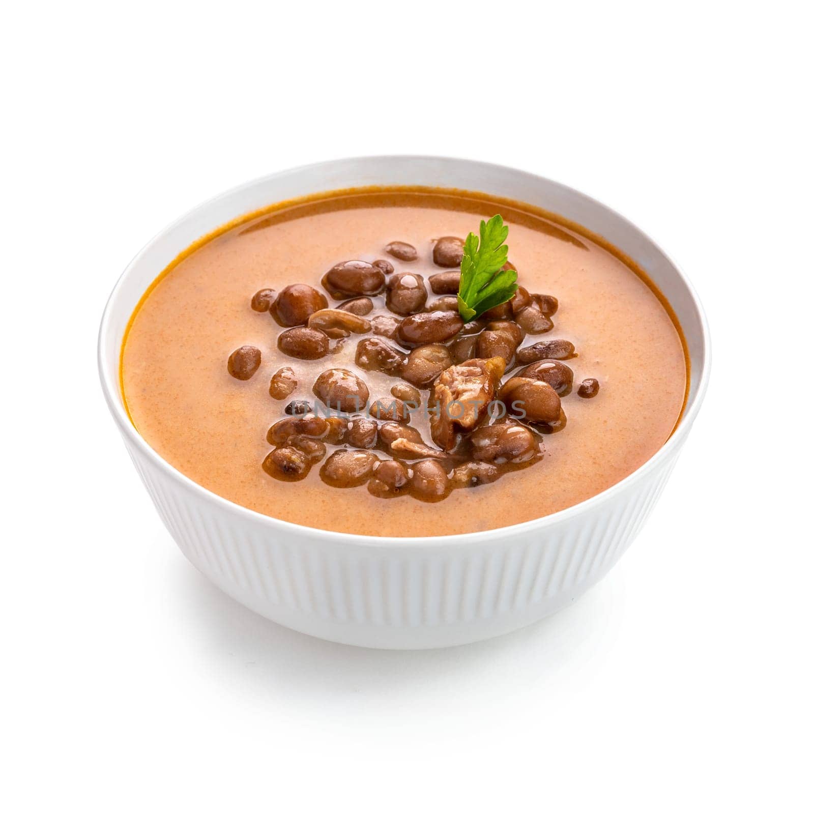 Dive into a bowl of hearty bean soup infused with tender pork pieces, offering warmth and comfort on a chilly day. The creamy white bowl highlights the rich colors and inviting aroma of this delicious dish