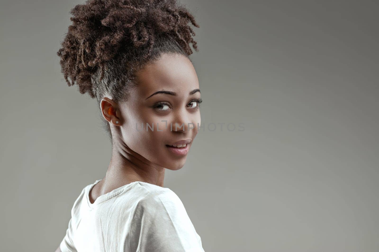 Almost facing away, she looks back with a lively, charming expression