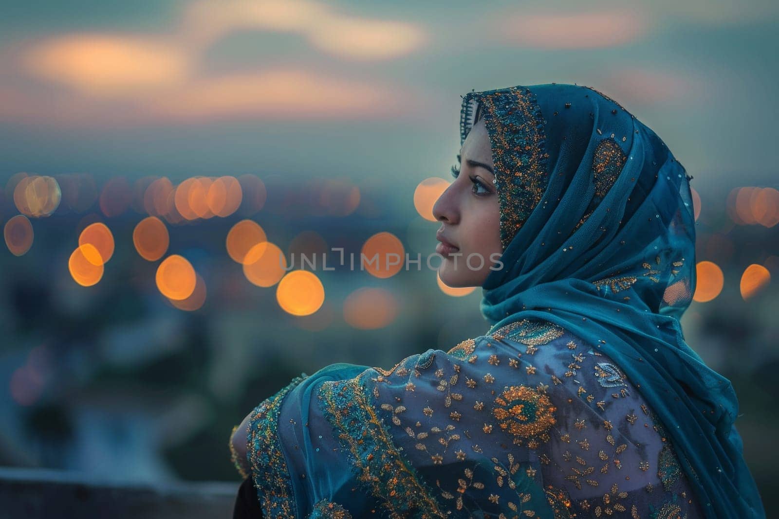 A contemplative woman in a beautiful hijab overlooks the city at dusk during Ramadan.