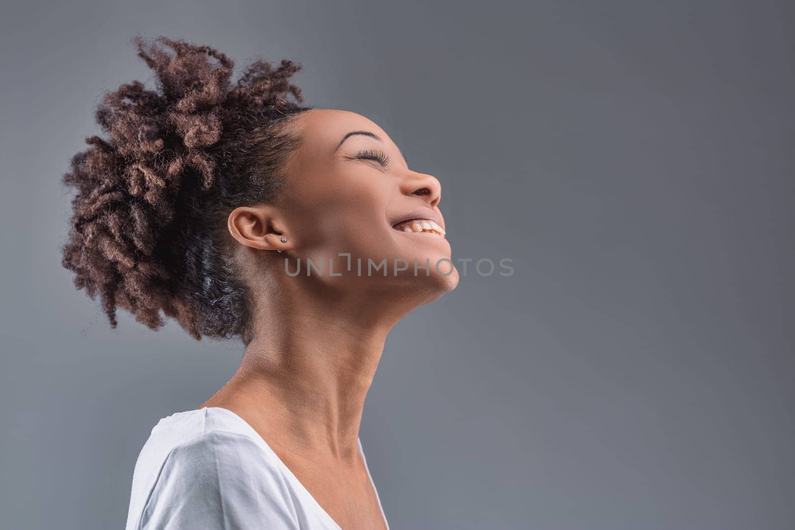 Exhilarating joy lights up the young woman's features, her head thrown back in a moment of pure happiness