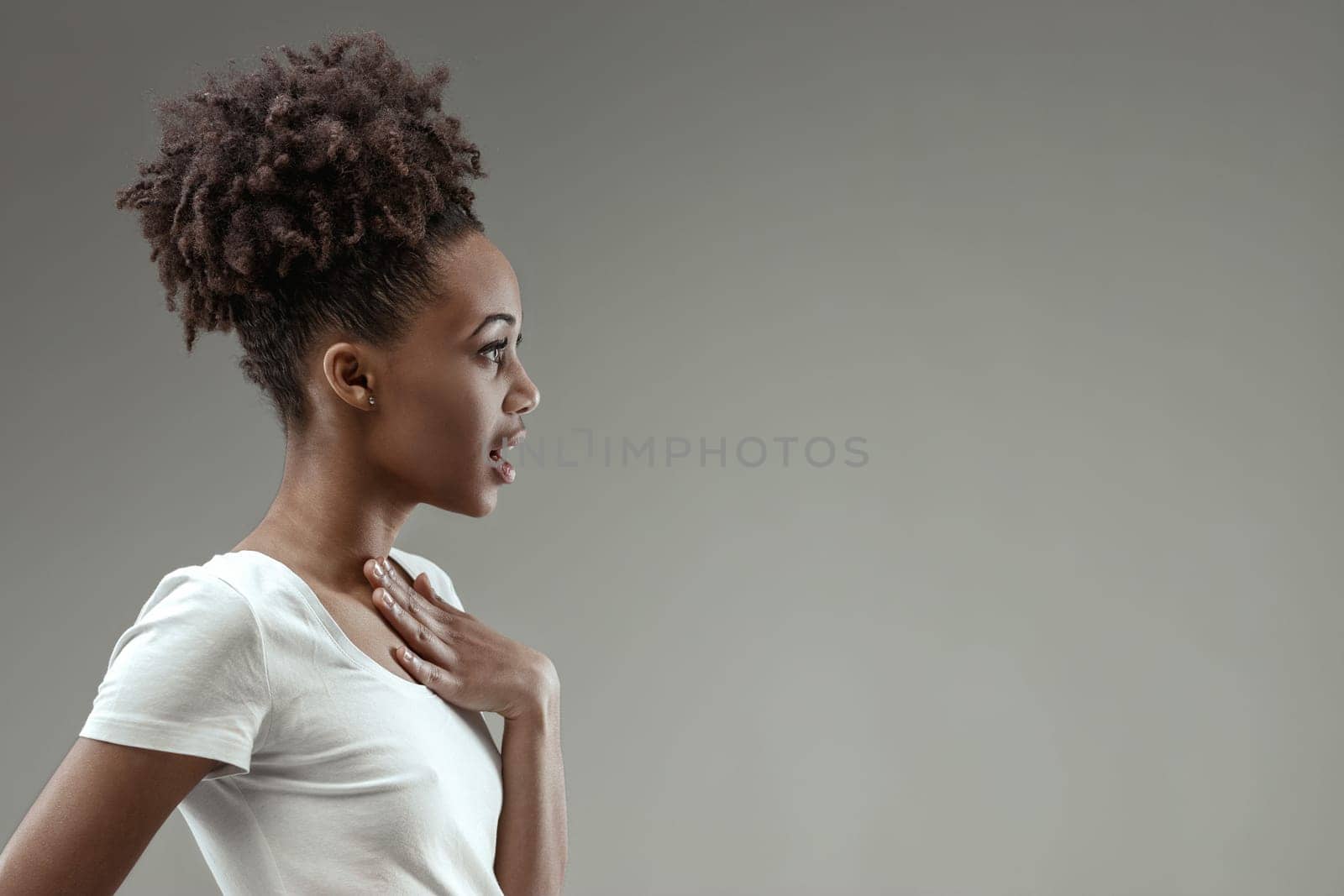 Astonishment crosses the woman's face, her hand on her chest, reacting to an unexpected honor