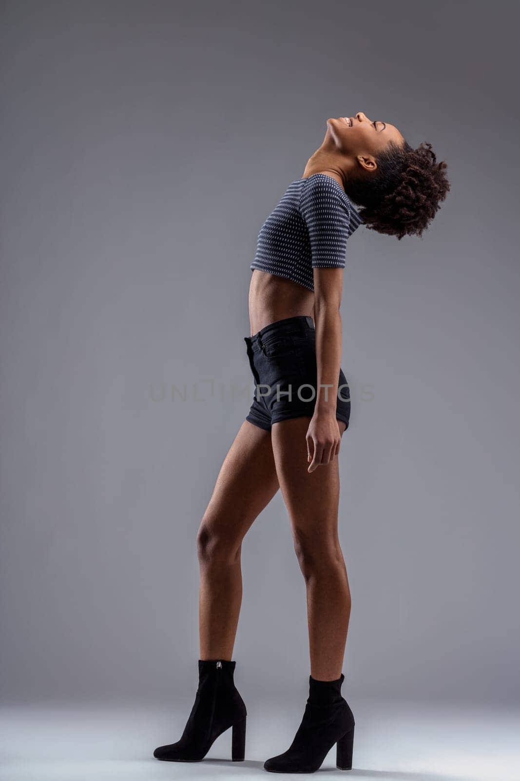 She portrays strength and flexibility, arching back in stylish attire