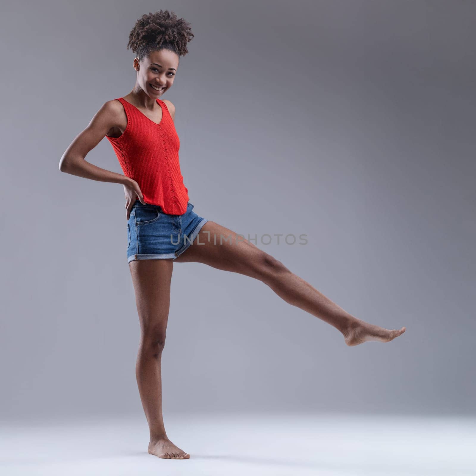 Full of vitality, she balances on one leg with an exultant smile