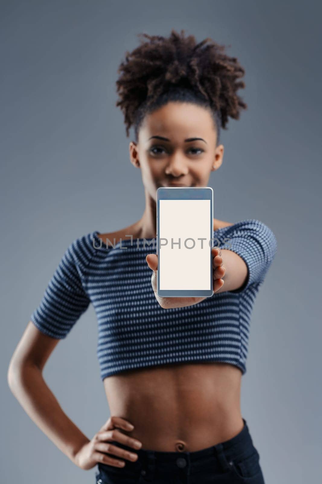 Excited young woman shows a smartphone, her expression reflecting the promise of modern communication