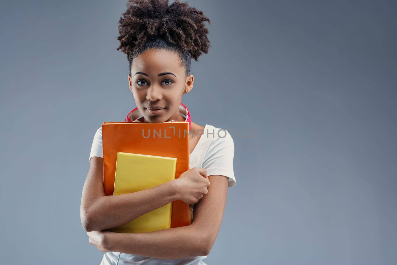 Studious young adult clutches educational materials with intent