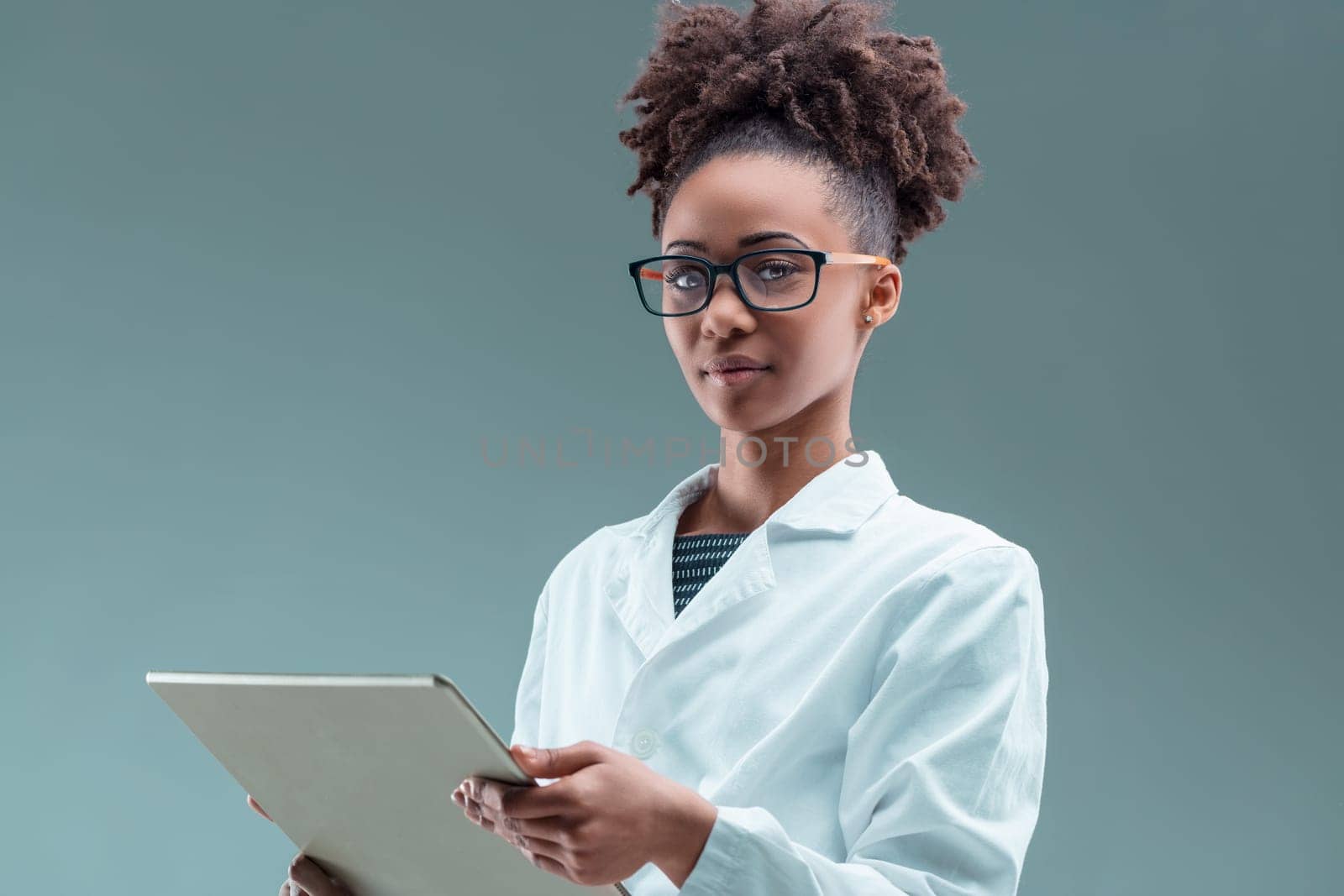 Engrossed in technology, the young professional woman navigates a tablet with a discerning eye
