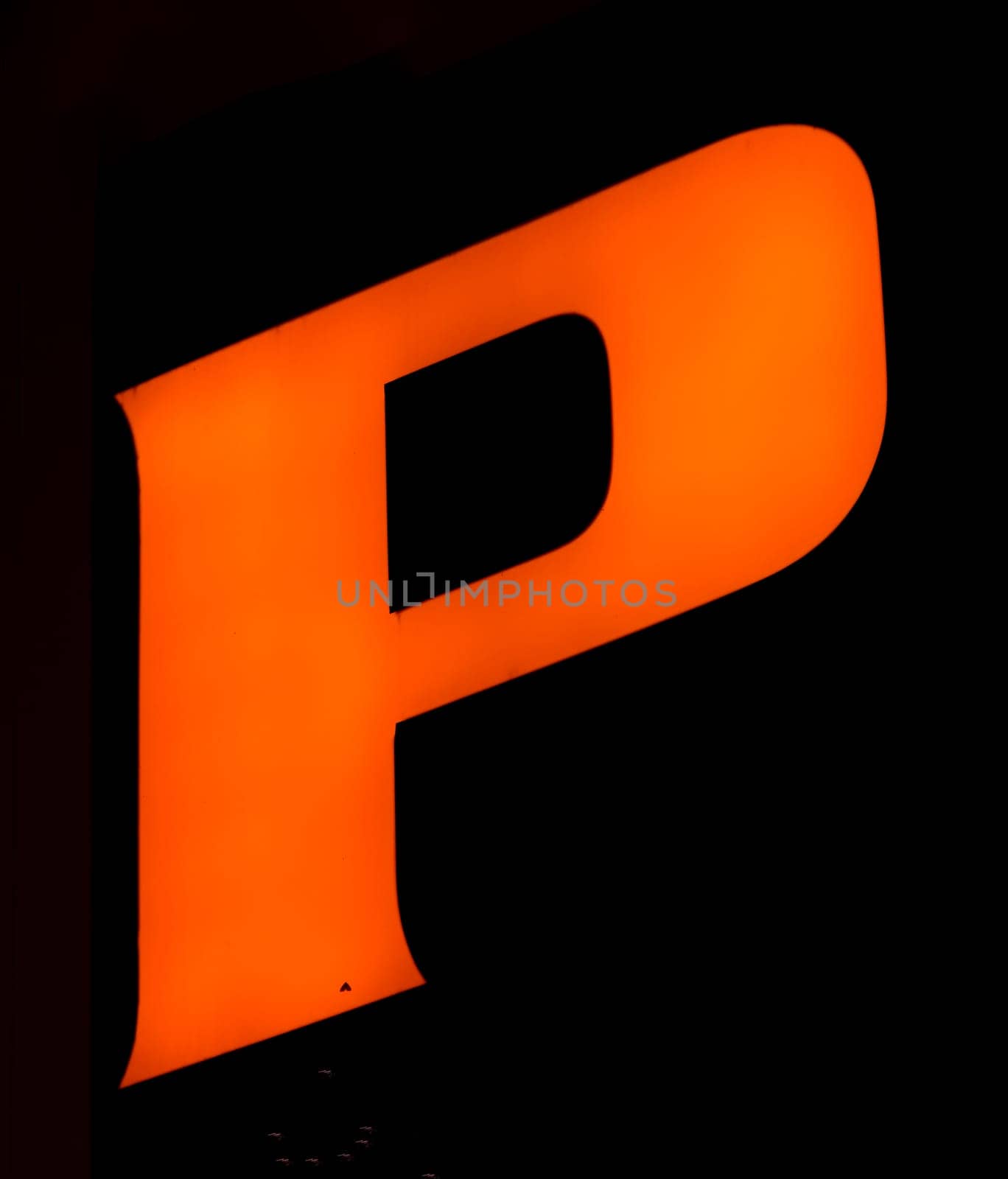 Fluorescent orange 'P' letter glows vibrantly against a shadowy backdrop, encapsulating power and presence