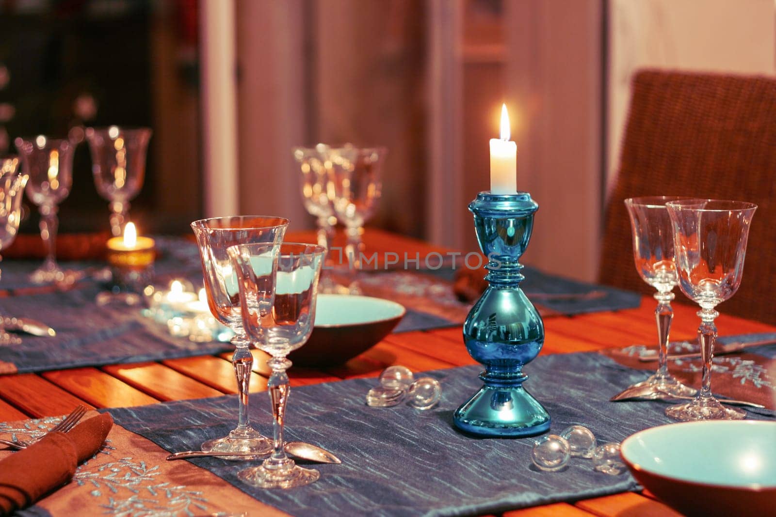Dining table setting with glasses, festive decorations and candles