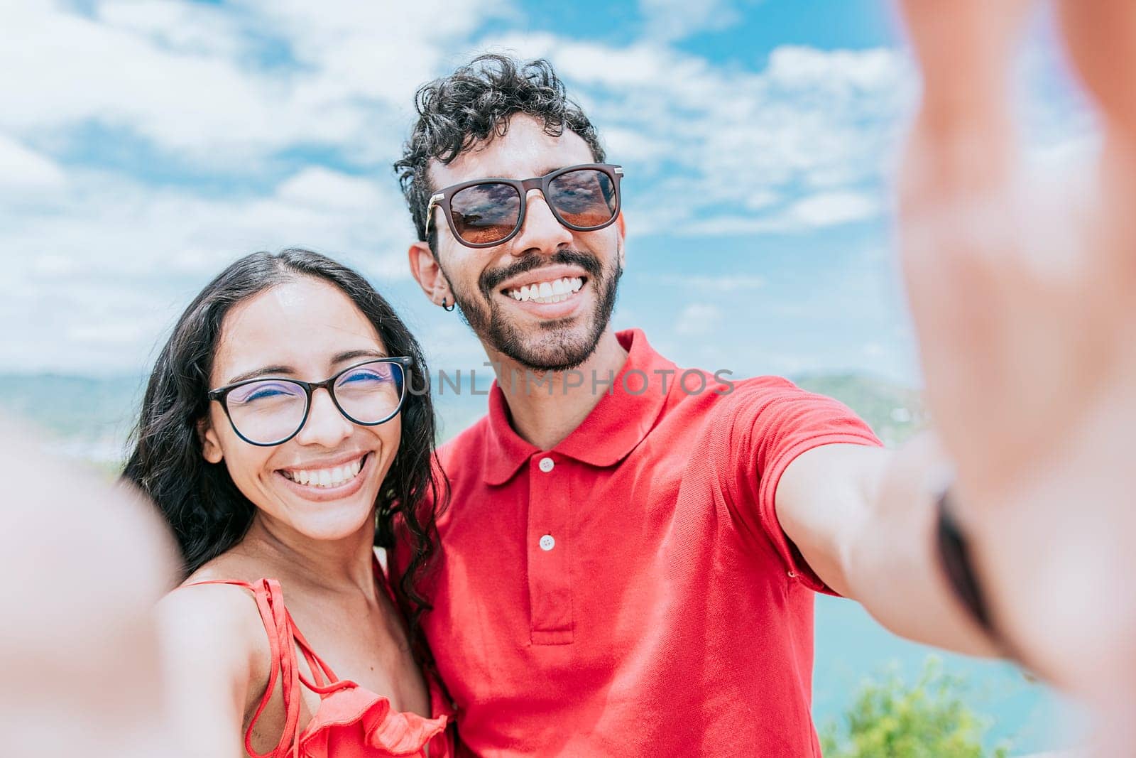 Happy Young couple on vacation taking a selfie near the beach. Smiling young couple taking a self portrait in the bay of San Juan del Sur
