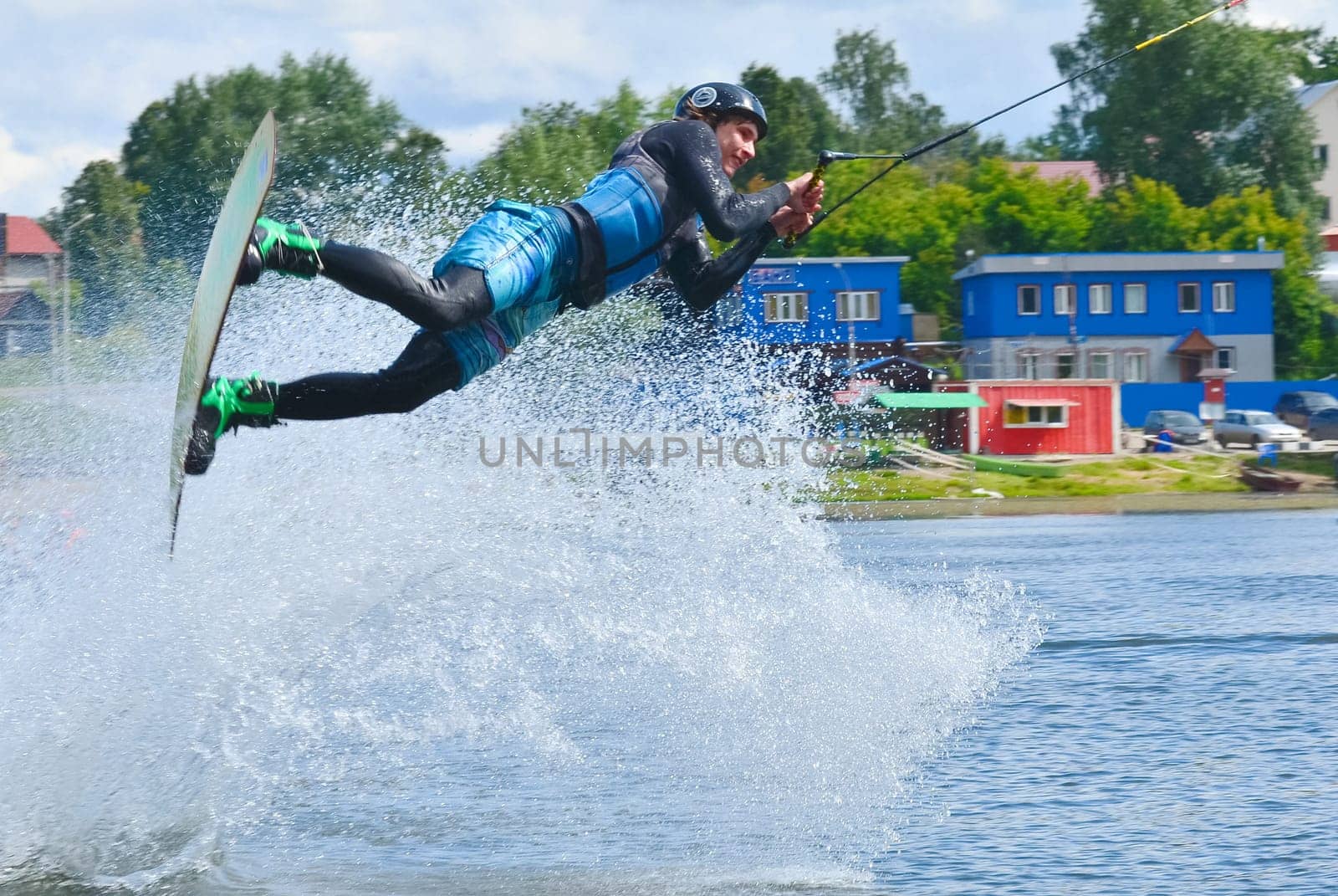Russia, Volgodonsk - June 18, 2015: Water snowboard. The athlete with snowboard hold on to the rope and the boat accelerates.